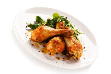 Roast chicken drumsticks on white background