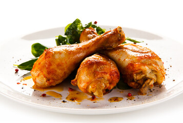 Roast chicken drumsticks on white background
