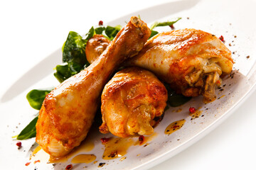 Roast chicken drumsticks on white background