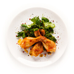 Roast chicken drumsticks on white background