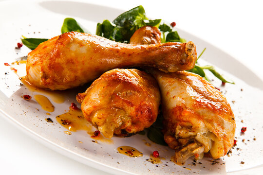 Roast chicken drumsticks on white background