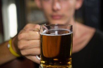 Man holding a mug of beer in bar