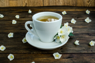 jasmine tea with jasmine flowers on wooden background