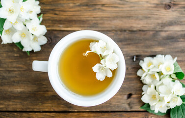 Obraz na płótnie Canvas jasmine tea with jasmine flowers on wooden background