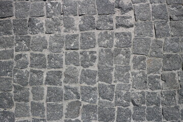 Rubble gray square stones paved road