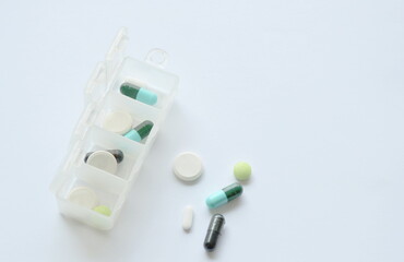 medical capsule and drugs in plastic box on white background