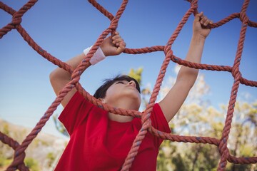 Boy climbing a net during obstacle course training
