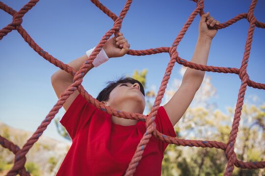 Boy climbing a net during obstacle course training