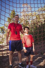 Trainer and boy standing together in the boot camp