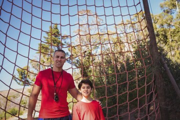 Trainer and boy standing together in the boot camp