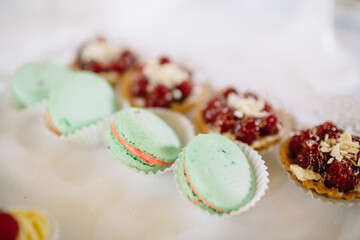 Mint macaroons and cookies with berries served on white dish