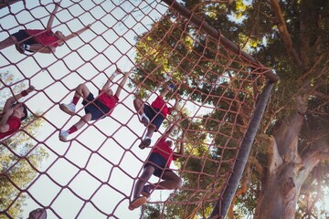 Fototapeta na wymiar Kids climbing a net during obstacle course training