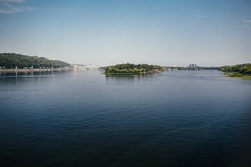 Broad river runs along green shore