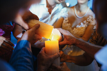 People lite their candles with newlyweds