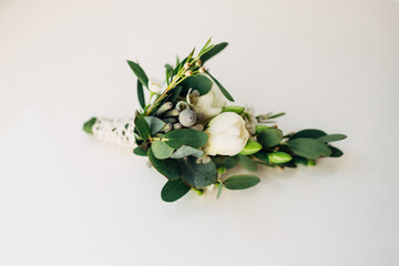 White boutonniere lies on white table