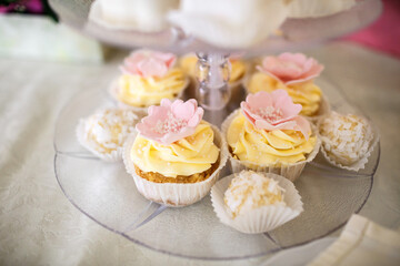 Cupcakes with yellow cream and pink flowers
