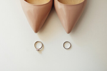 Wedding rings stand before bride's shoes