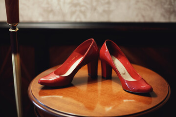 Red shoes stand on the dressing table under the lamp