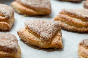 Many puff pastry cookies on white surface