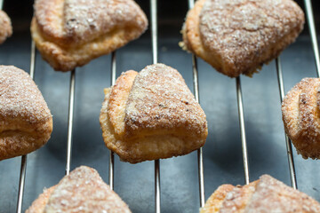 Few puff pastry cookies on metal grid