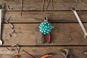 Pliers with ribbon amidst hand tools on table