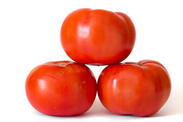 Three red tomatoes in a pile isolated on white background