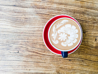 Hot mocha coffee or capuchino in the green cup with luxury pattern on the wooden table