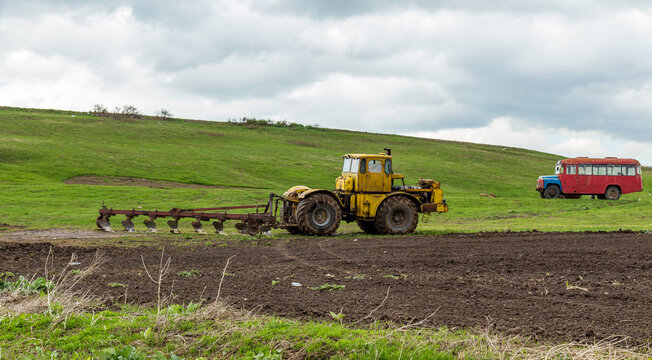 The tractor plows the land in the fields in the spring