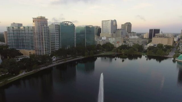 Aerial reveal flying backwards over Lake Eola fountain in downtown, Orlando, FL in August 2016.  