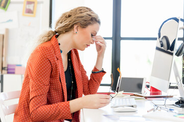 Obraz premium Young woman in office tired