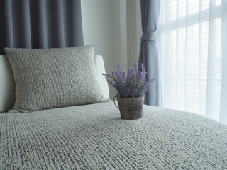 beautiful purple lavender flower on modern vintage sofa and blurry beautiful white drape window texture background.