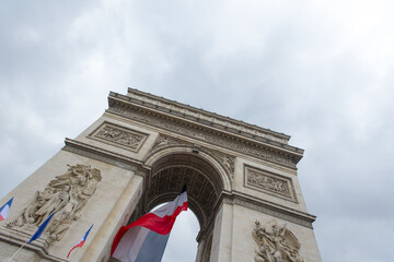 Fototapeta na wymiar Panoramic view of Arc de triomphe and French flags in Paris