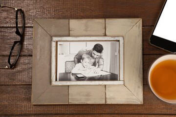 Picture frame with coffee cup and mobile phone on table
