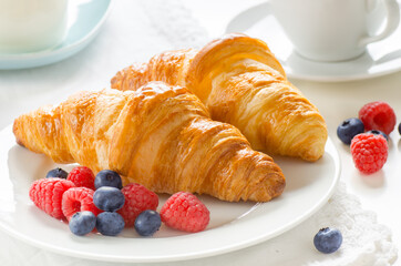 Breakfast of freshly baked croissants with berries and coffee