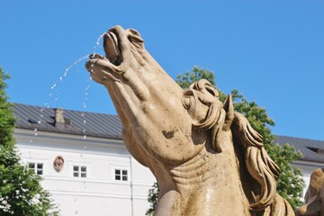 Fototapeta na wymiar Horse sculpture: detail of the famous baroque Residence fountain in Salzburg, Austria, Europe. Built in 1661, located on the Residence Square.