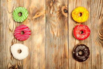 Colorful donuts on wooden background