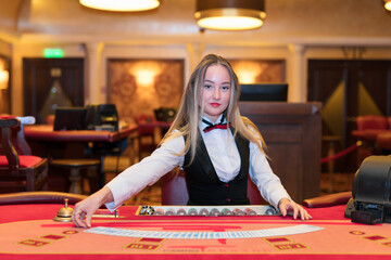 Cute lady casino dealer at poker table.
