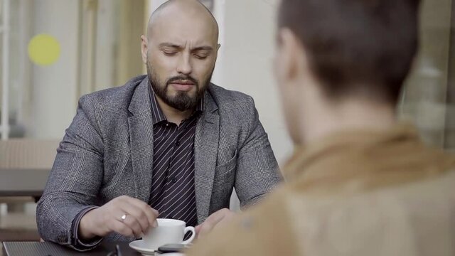 Colleagues talking in the lunch break at an outdoor cafe with a Cup of tea.