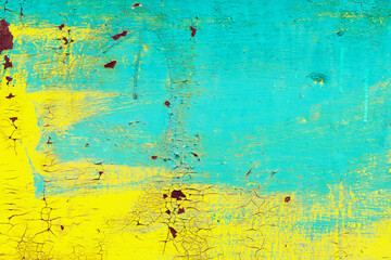 Closeup image of grunge yellow and cyan wall with aged paint as an abstract background.