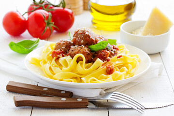 Egg tagliatelle with meatballs in tomato sauce.