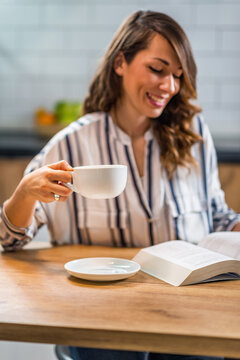 Woman drinking coffee and reading book