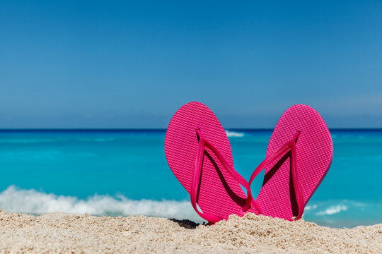 Flip flops on the sandy ocean beach , tropical vacation concept