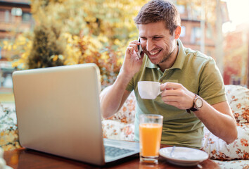 Young man sitting in the cafe and working with laptop. Lifestyle, technology concept