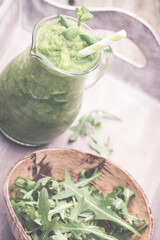 Rucola smoothie, on the grey  background.