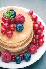 Stack of pancakes with blueberry and fresh berry.