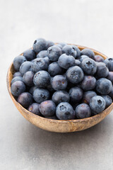 Fresh blueberries natural coconut in a bowl on a gray background.
