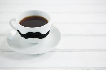 Coffee cup with mustache on white table
