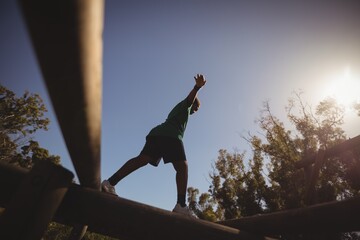 Boy exercising on obstacle during obstacle course