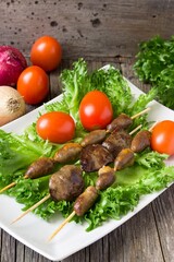 Barbecue  chicken hearts and  liver  with tomato and salad.