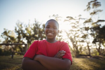 Portrait of smiling boy standing with arms crossed 